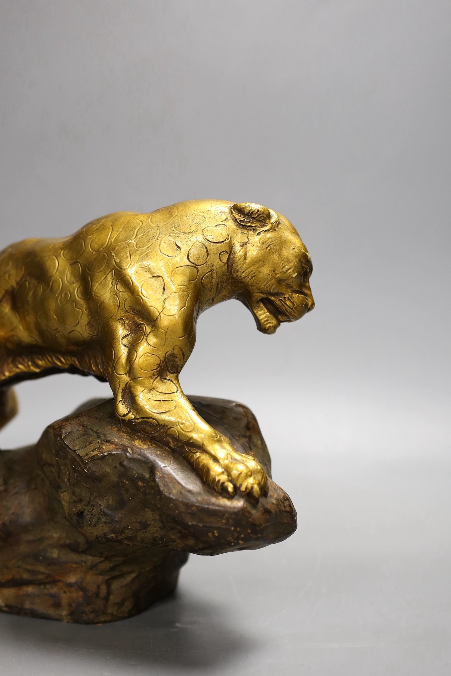 A gilt terracotta model of a panther on a rock, 21cms high